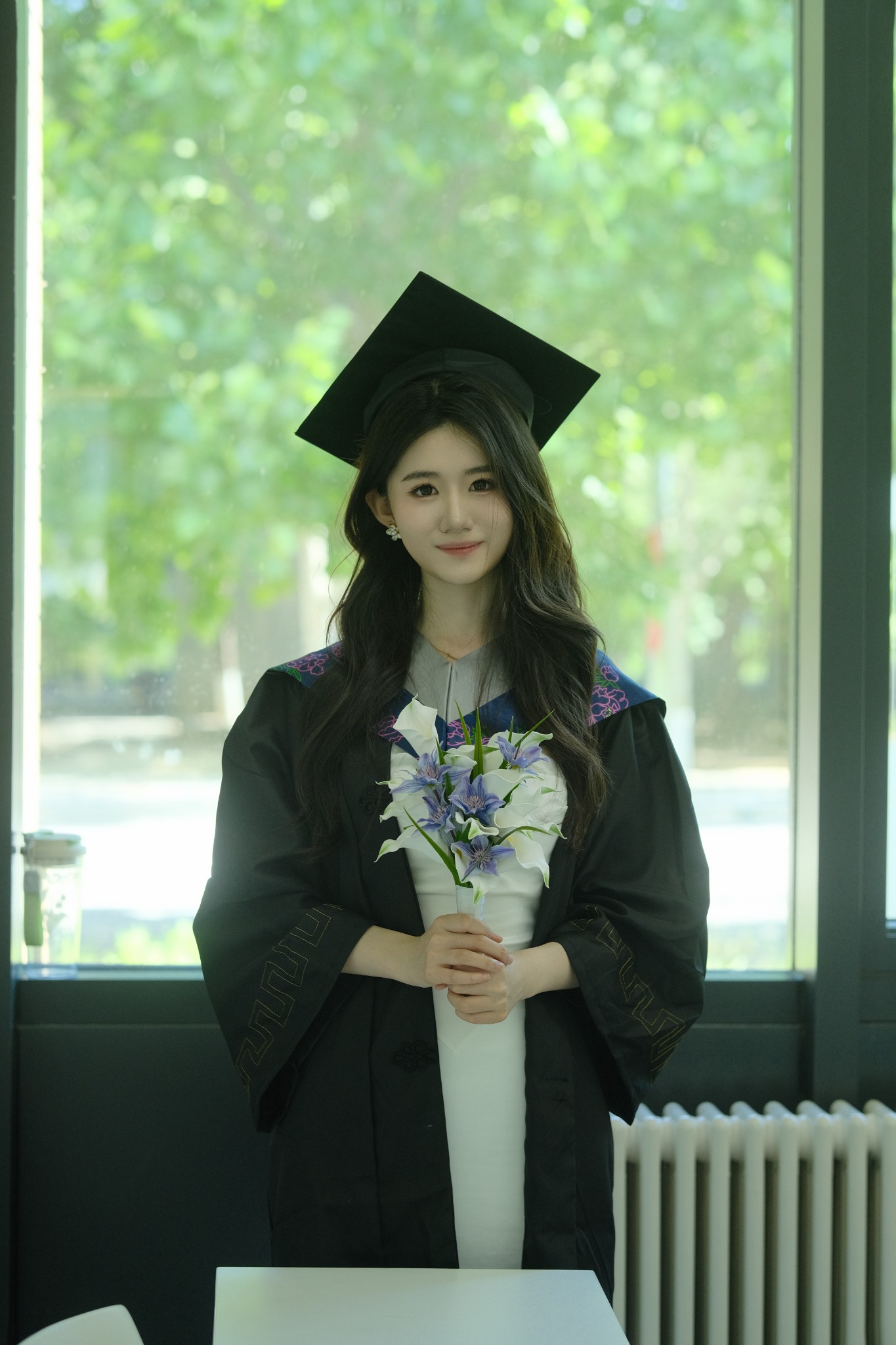 Xinyue Zhang at graduation, holding flowers
